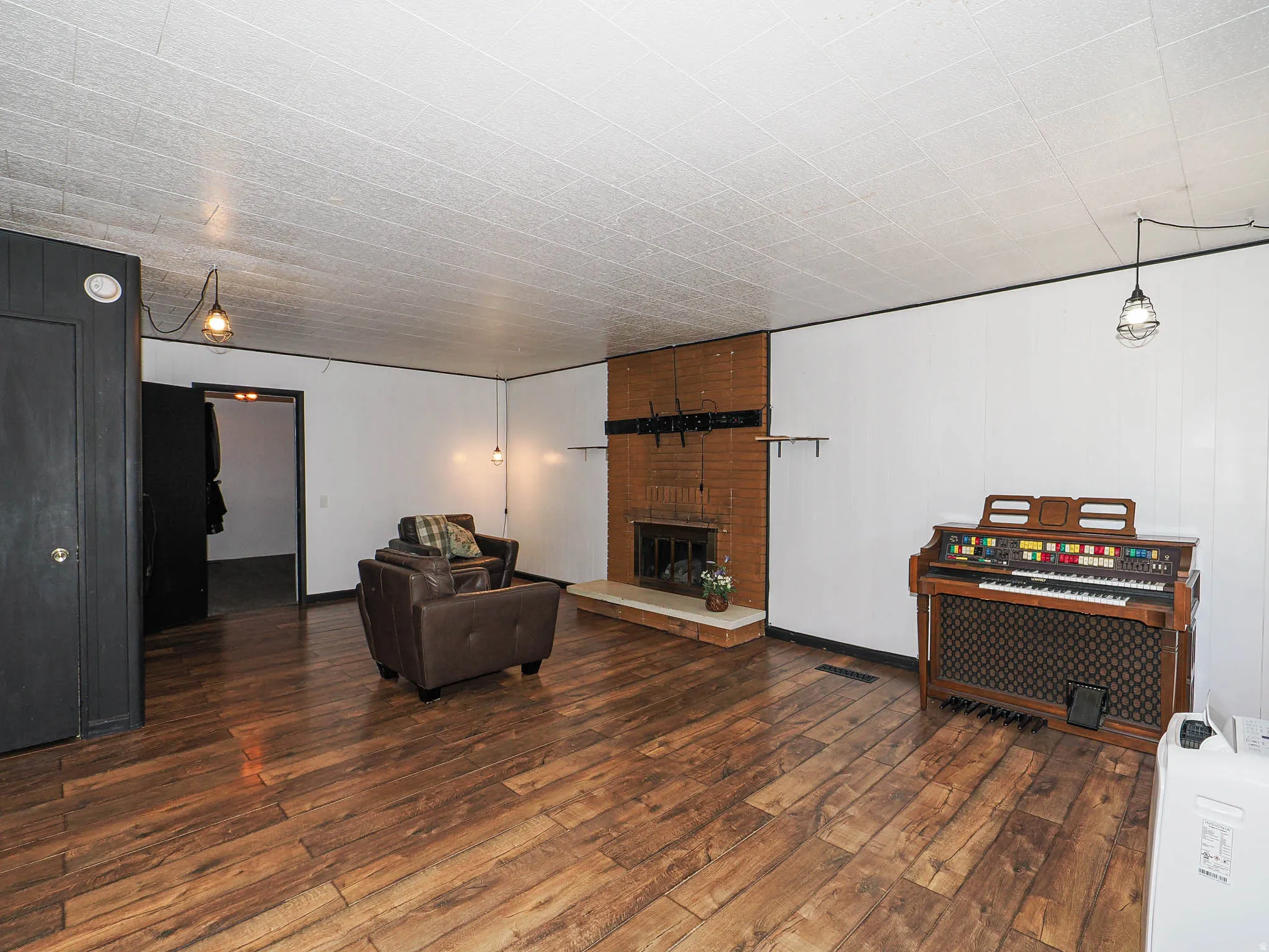 Spacious living area featuring wood-finish flooring, a large coat closet.