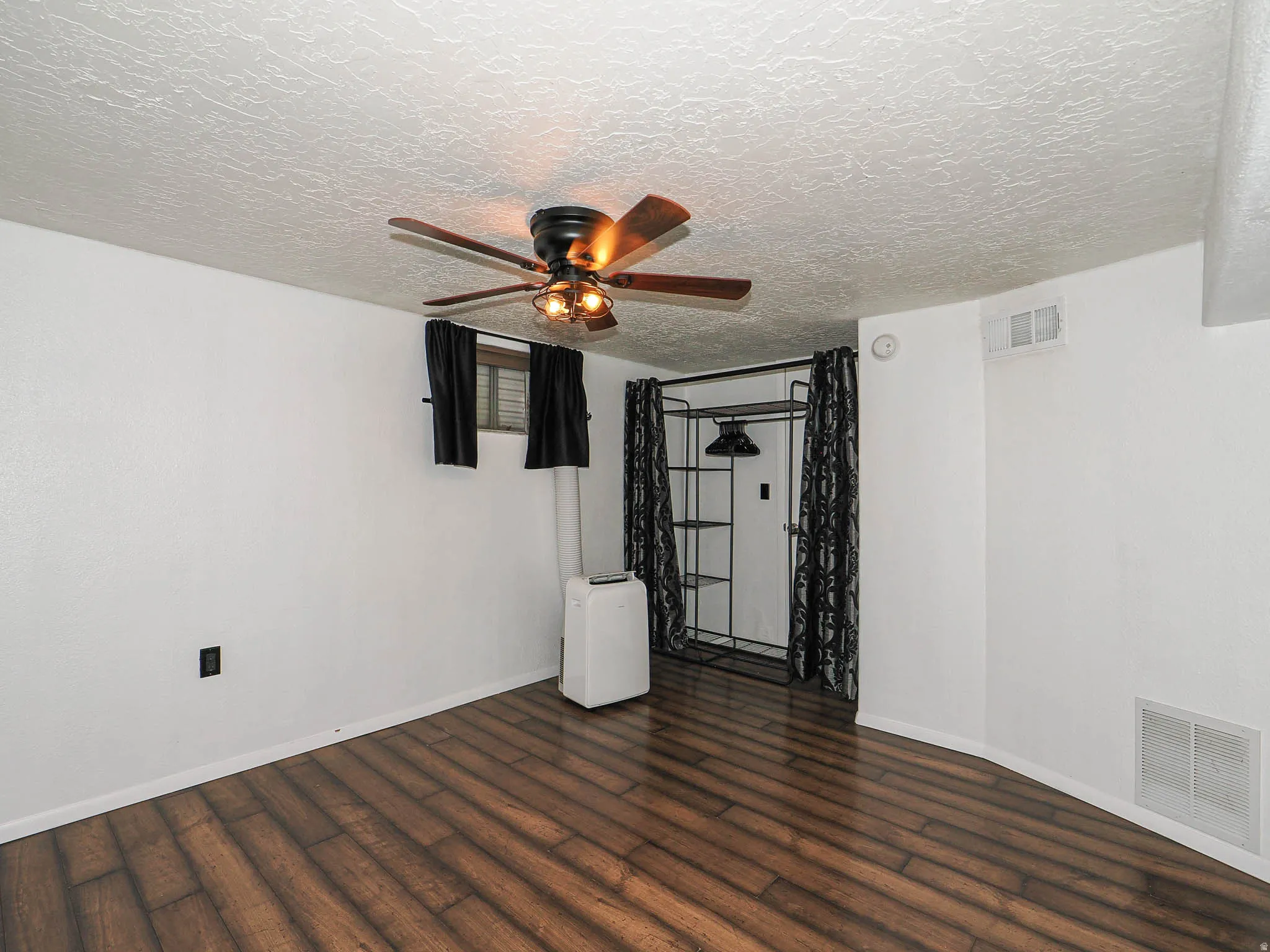Room featuring wood-finish flooring, a closet and a ceiling floor.