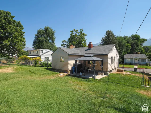 Across from Golf Course!   Spacious backyard featuring a large grass area, a concrete patio, and a covered gazebo
