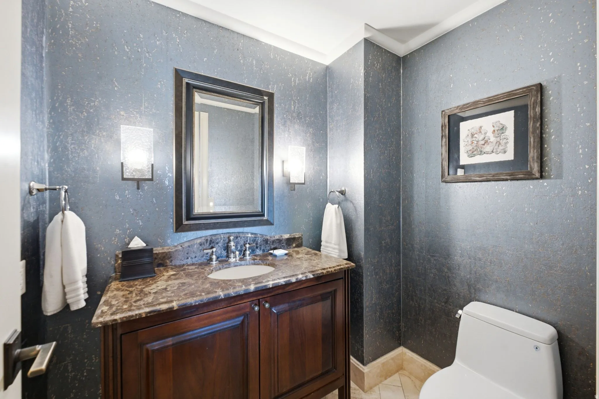 Powder room featuring a dark wood vanity with a stone countertop and an undermount sink