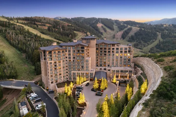 Luxury mountain resort residence showcasing a striking mid-rise residential tower with warm-toned exterior facade and extensive fenestration