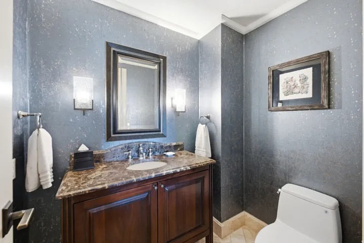 Powder room featuring a dark wood vanity with a stone countertop and an undermount sink