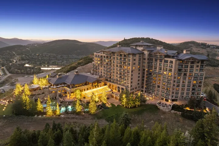 Multi-story building featuring numerous balconies and a large, multi-level recreational area with multiple pools