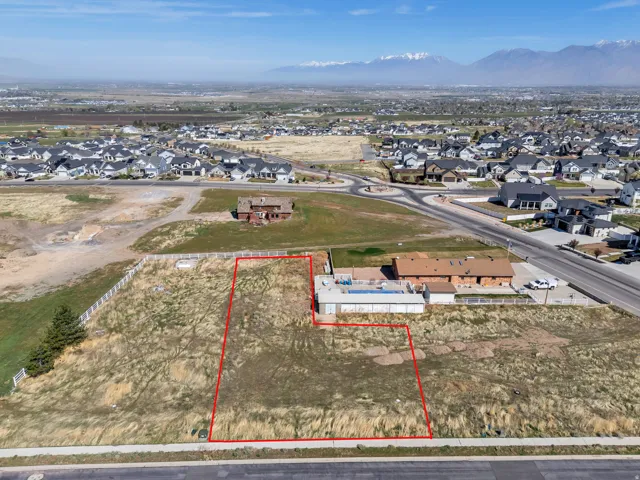 Expansive undeveloped lot featuring a defined perimeter, street frontage, and distant mountain scenery