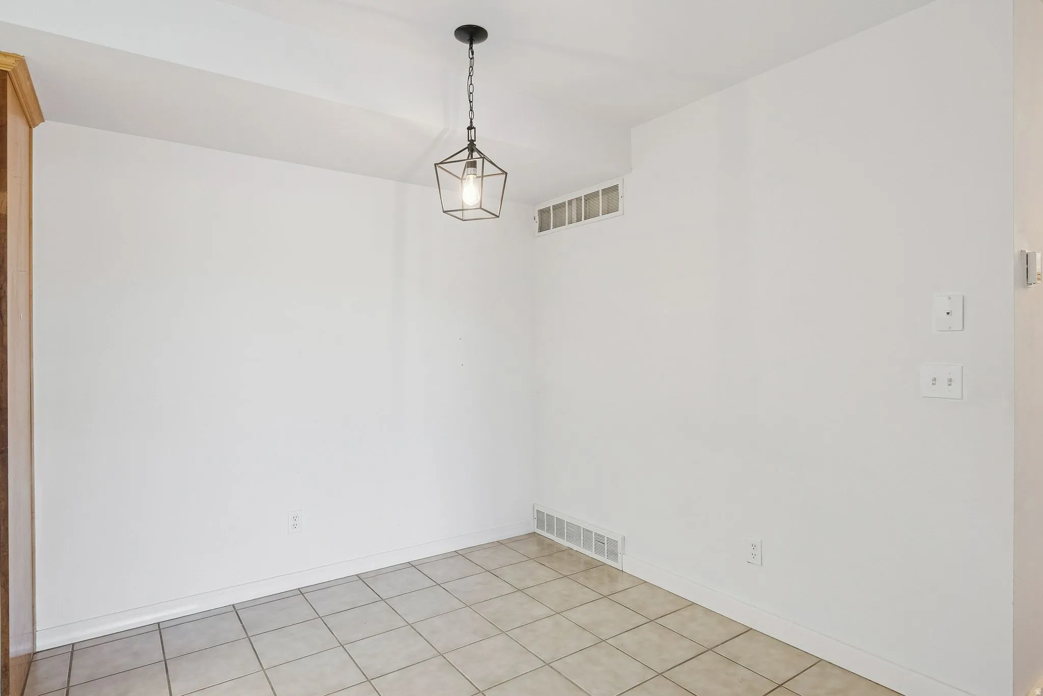 Neutral-toned ceramic tile flooring with white baseboards and walls