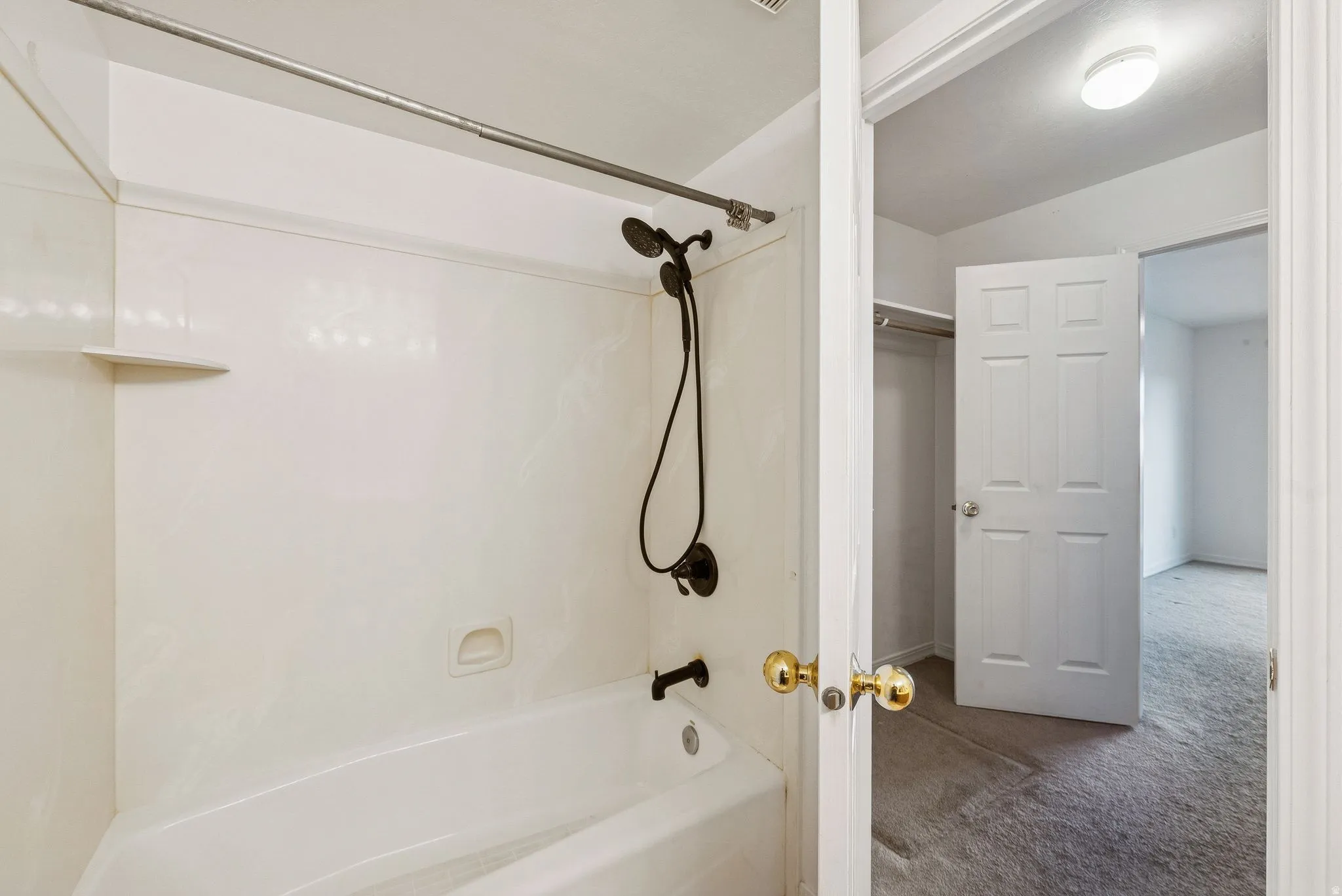 Bathroom featuring a white tub and shower combination with dark bronze fixtures