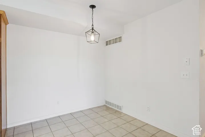 Neutral-toned ceramic tile flooring with white baseboards and walls
