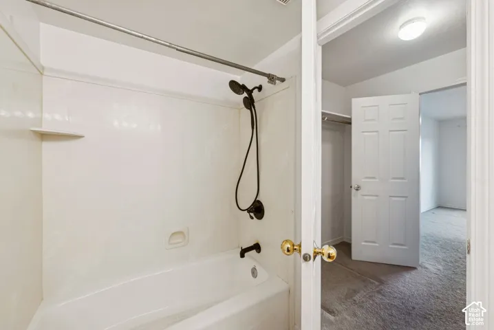 Bathroom featuring a white tub and shower combination with dark bronze fixtures
