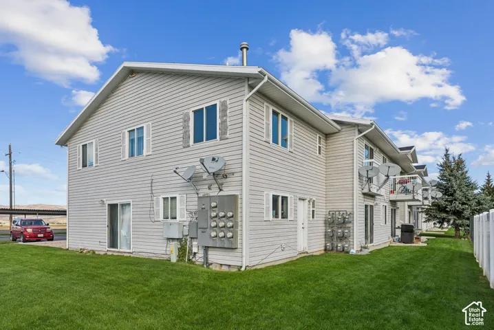 Multi-unit property with light gray horizontal siding, white trim, and a gabled roofline