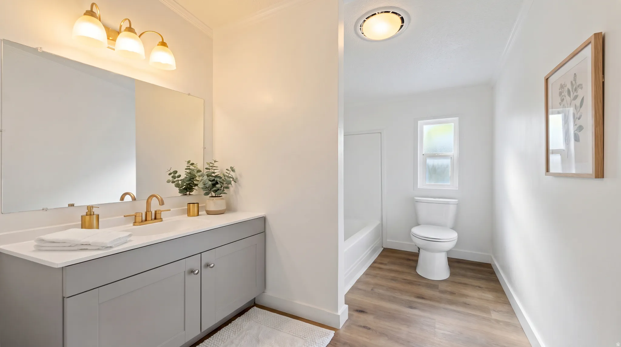 Bathroom featuring a vanity with a light gray cabinet, white countertop, and gold-finish hardware