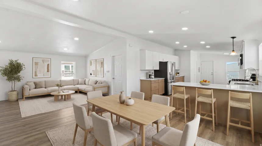 Open-concept living space with wood-finish flooring, vaulted ceilings, and recessed lighting