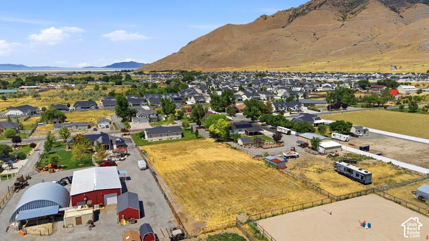 Aerial perspective showcasing expansive land parcels with a backdrop of a mountainous landscape