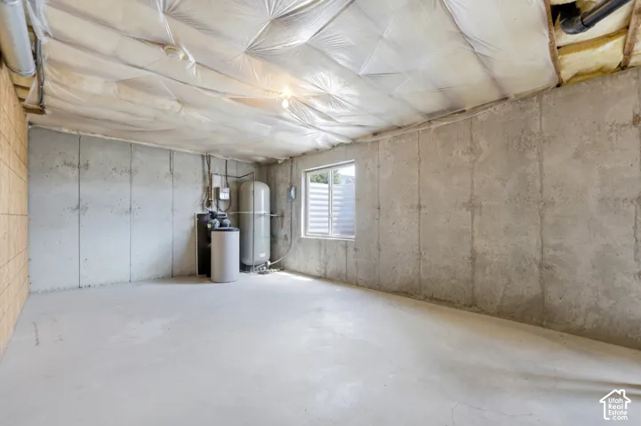Unfinished basement space featuring exposed concrete walls and flooring