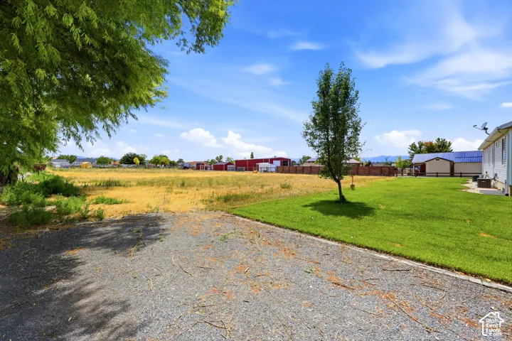 Expansive gravel hardscaping providing ample parking and access to a broad grassy area