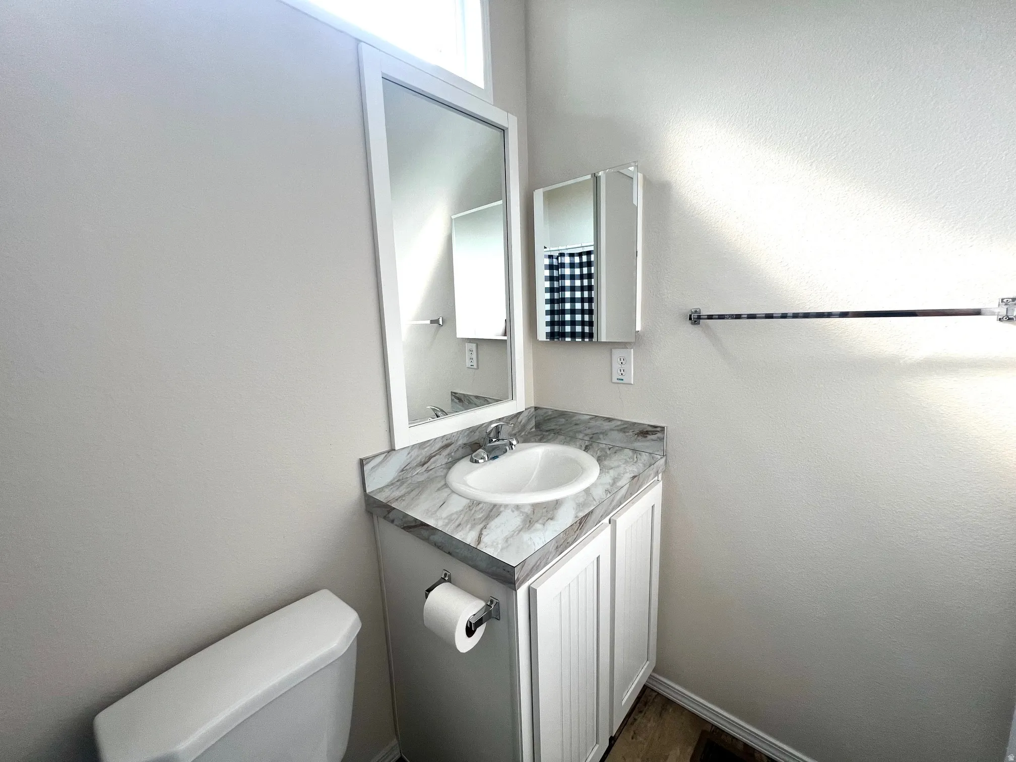 Bathroom featuring a single vanity with a white basin and a stone-look countertop