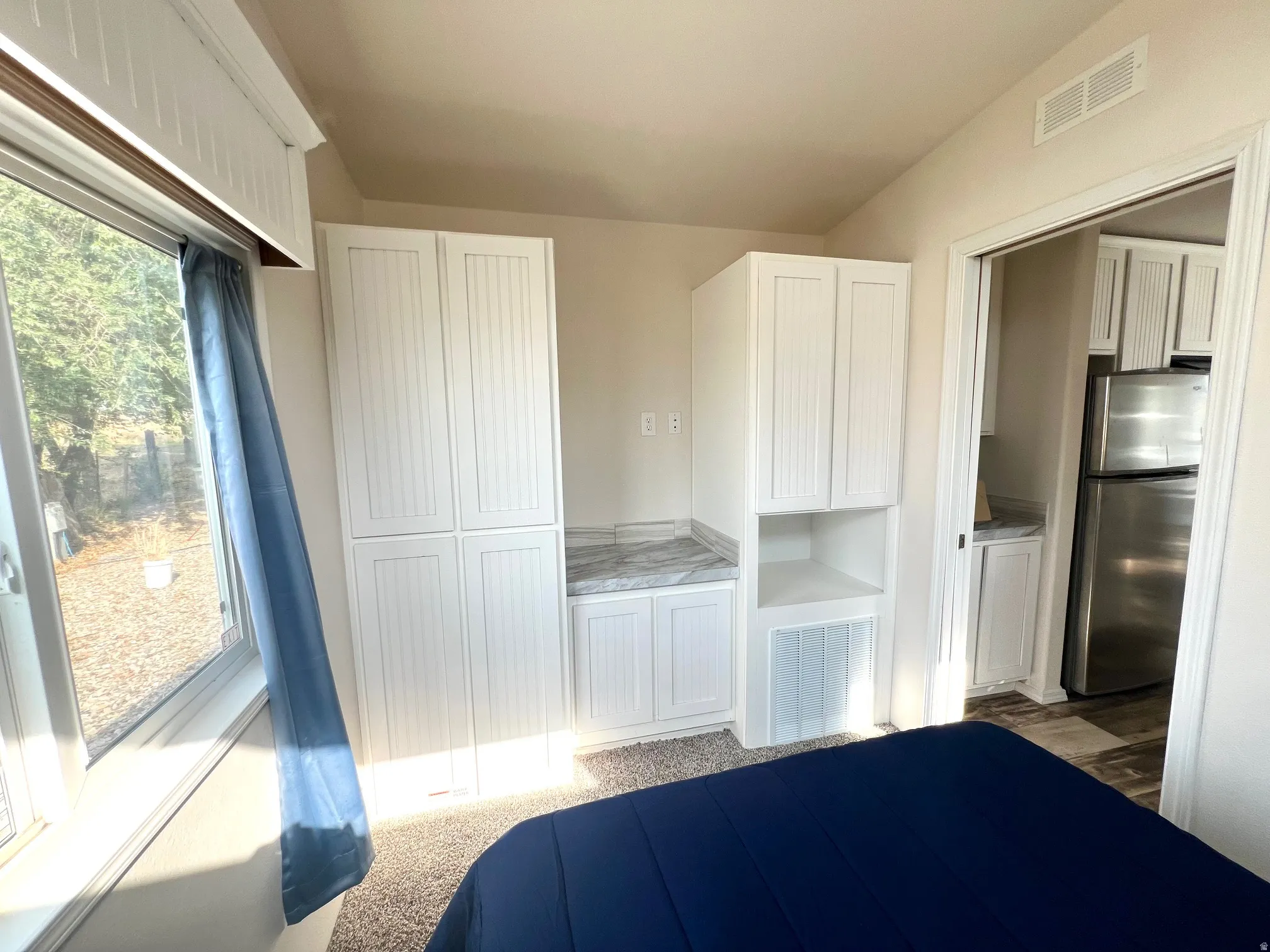 Built-in cabinetry with beadboard paneling, integrated shelving, and a light-toned countertop