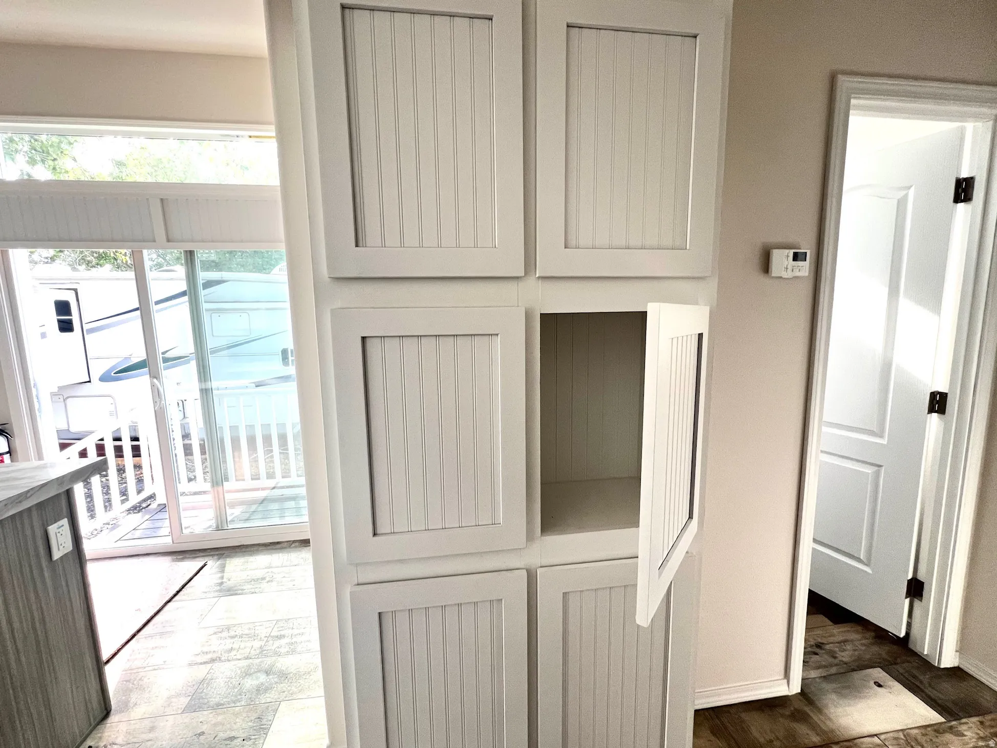 Built-in white beadboard cabinetry offering extensive storage