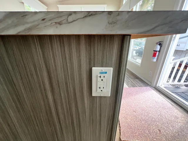 Wood-finish cabinetry with a white electrical outlet