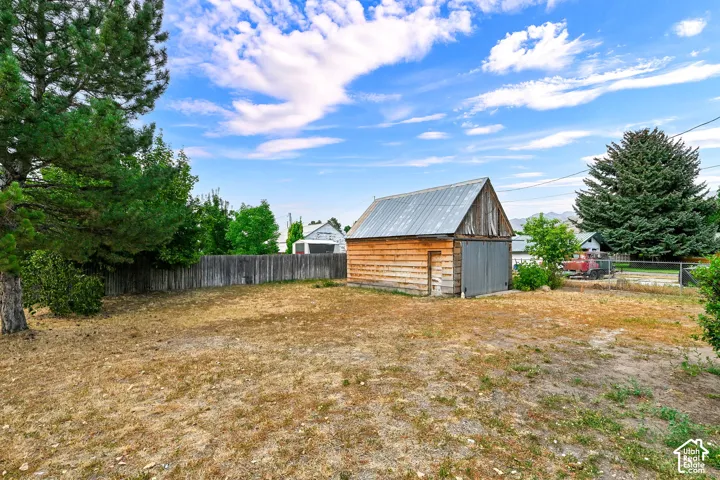 Outbuilding with natural wood siding and a corrugated metal roof