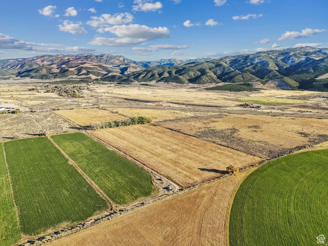Expansive agricultural land featuring diverse fields and distant mountain ranges