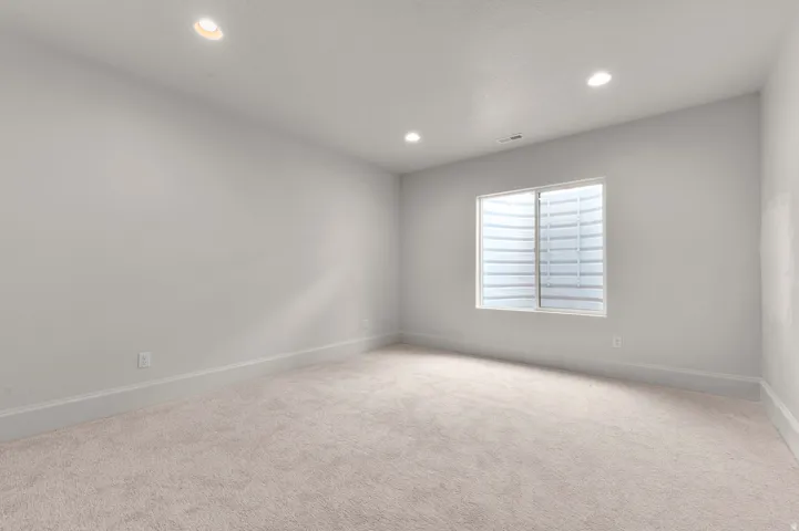 Spacious room featuring light-toned carpeting and neutral wall paint