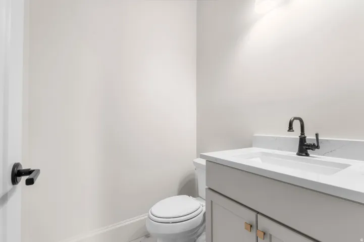 Bathroom featuring a contemporary vanity with an integrated sink, matte black faucet, and a light-toned countertop