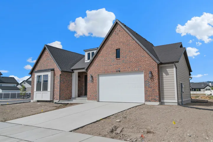 Brick and siding exterior featuring a prominent two-car garage