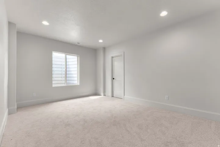 Spacious room featuring light-colored carpeting and recessed ceiling lighting