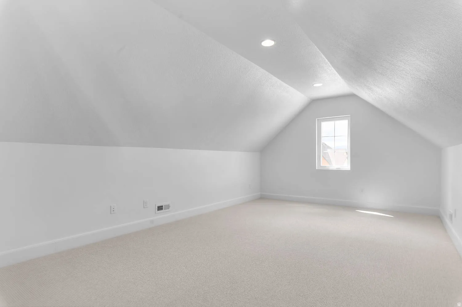 Carpeted room featuring an attic ceiling with recessed lighting