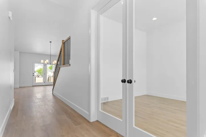 French doors featuring matte black hardware opening to a versatile room with recessed lighting