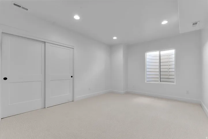 Spacious room featuring neutral carpeting and white walls