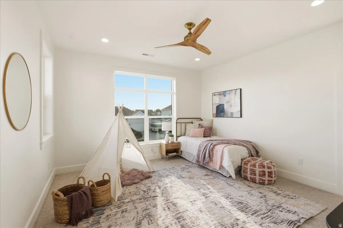 Light-filled room featuring a large multi-pane window, recessed lighting, and a wood-finish ceiling fan