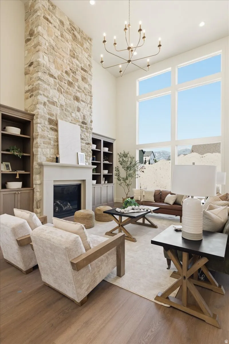 Two-story living area featuring a floor-to-ceiling stone-clad fireplace and expansive windows