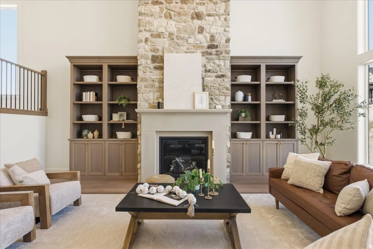 Stone-clad fireplace with a neutral mantel, flanked by built-in cabinetry with open shelving and lower storage