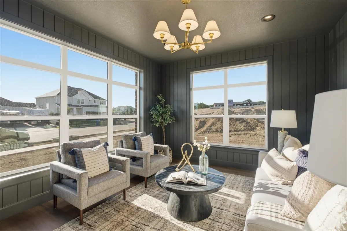 Room featuring dark vertical plank paneling, wood-finish flooring, and a multi-pane window composition