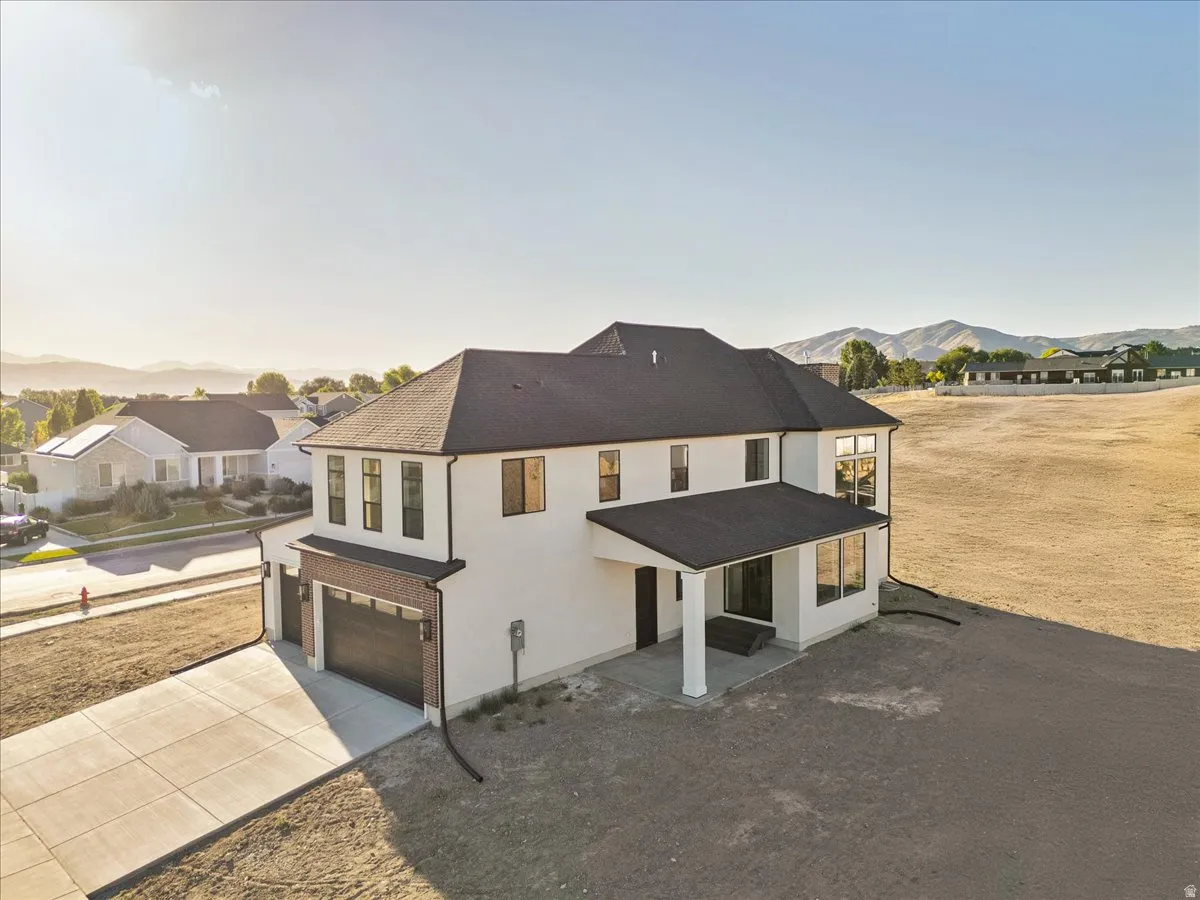 Contemporary two-story residence featuring a white stucco exterior with dark trim windows