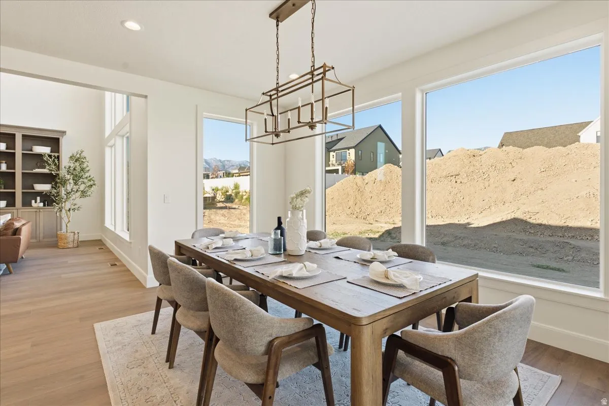 Open-concept dining area featuring an overhead chandelier and expansive windows