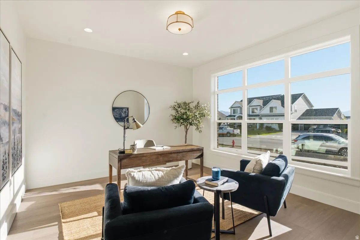 Bright room featuring wood-finish flooring, recessed lighting, and a prominent multi-pane window