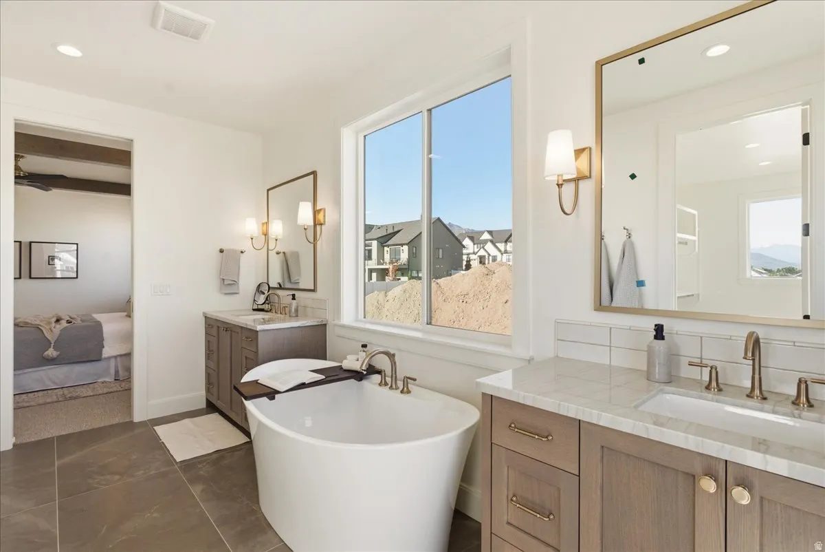 Freestanding soaking tub with brushed nickel fixtures, complemented by a large window