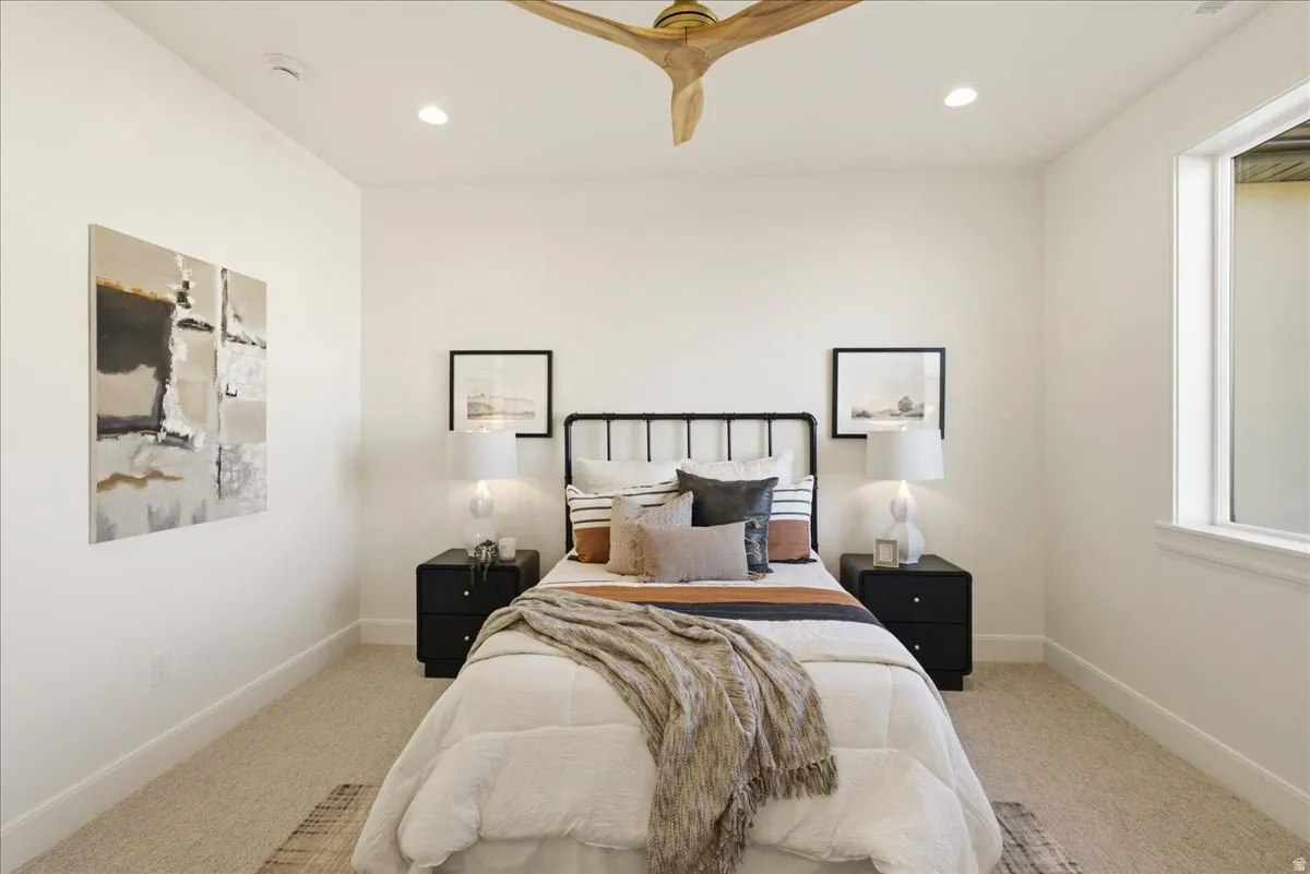 Bedroom featuring a light wood-finish ceiling fan, recessed lighting, and a window with white trim
