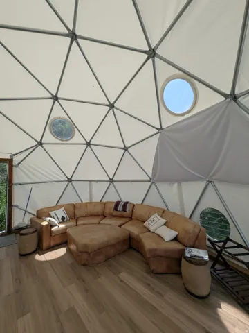 Geodesic dome interior featuring a light-toned textile covering and a prominent structural framework