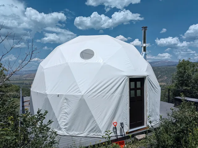 Geodesic dome structure featuring a white exterior and a circular window
