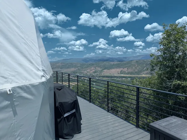 Expansive composite deck featuring a horizontal bar railing and panoramic mountain scenery