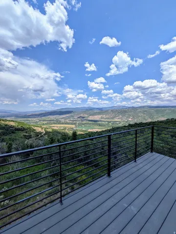 Spacious outdoor deck featuring composite decking and a modern horizontal bar railing