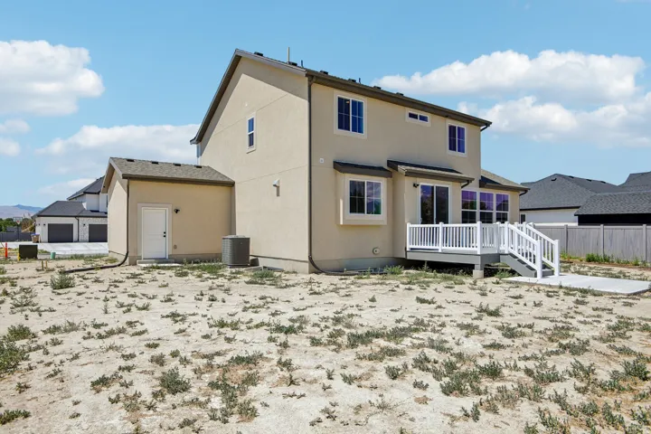 Neutral-toned stucco exterior with a multi-level deck featuring white railings and steps