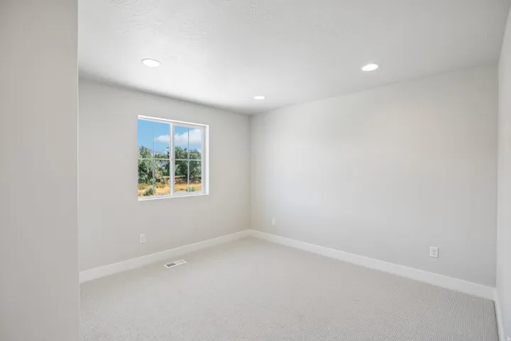 Carpeted room featuring a double-pane window, recessed lighting, and light gray wall paint
