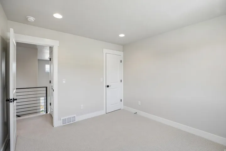 Carpeted room featuring light gray walls, white trim, and recessed lighting