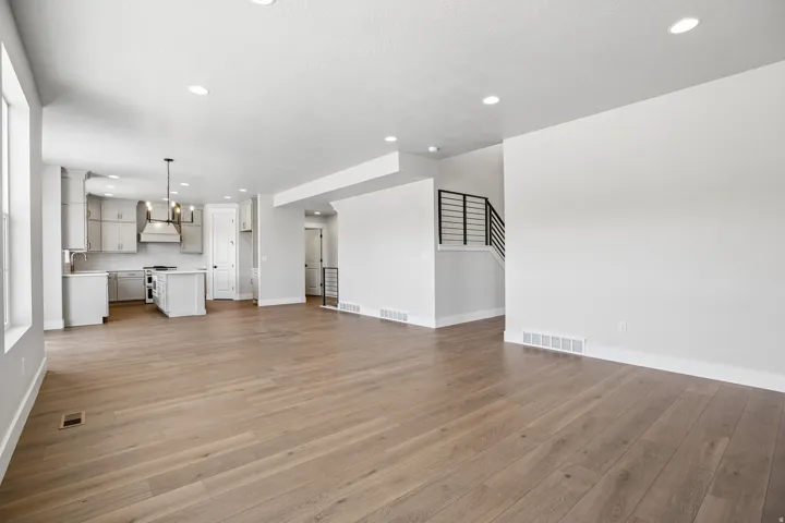 Open-concept living area featuring wood-finish flooring, recessed lighting, and white baseboards