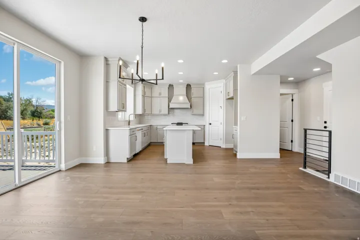 Open-concept living area featuring wood-finish flooring and a contemporary kitchen