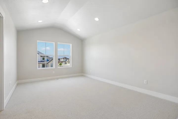 Vaulted ceiling room featuring recessed lighting, a neutral color palette, twin windows, plush carpeting, and crisp white baseboards